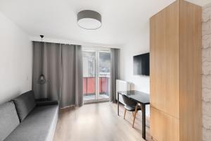 una sala de estar con un escritorio y una mesa en Apartamenty Platinex 1, en Cracovia