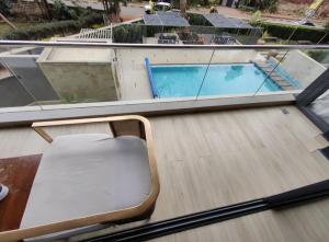 Una silla vacía sentada en un balcón junto a una piscina. en Riverside Square, en Nairobi