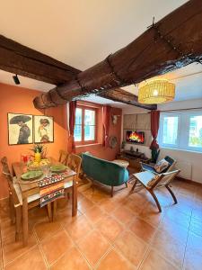Casa Tulum في تولون: غرفة معيشة مع طاولة وكراسي ومدفأة