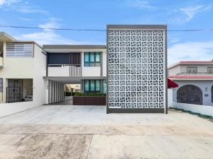 圣胡安Hyde Park 2 Comfy Apt with Parking San Juan的砖墙白色房子