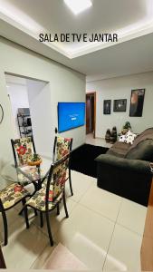 een woonkamer met een bed en 2 stoelen bij Aconchego e praticidade in Mineiros