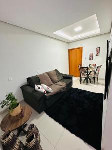 een woonkamer met een bank en een tafel bij Aconchego e praticidade in Mineiros