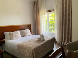 a hotel room with a bed with a window at Hotel Louro in Óbidos +40 photos