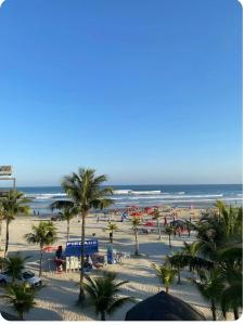 a view of a beach with palm trees and the ocean at Casa de Praia in Bertioga +15 photos