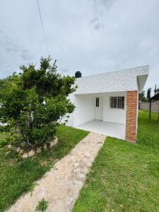 a white house with a tree in the yard at Casa en Nono traslasierra in Nono