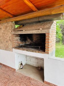 an outdoor brick oven with a wooden roof at Casa en Nono traslasierra in Nono
