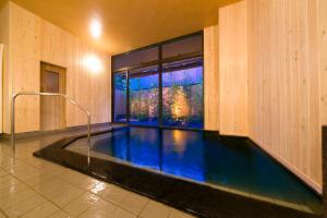 a swimming pool in a building with a large window at Kanazawa Chaya in Kanazawa