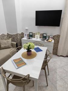 a living room with a white table with chairs and a tv at Casa vacanze Carmen House in Ercolano