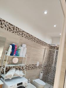 a bathroom with a toilet and a shelf on the wall at Casa vacanze Carmen House in Ercolano +122 photos