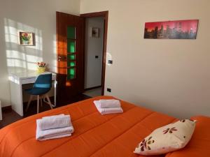 Una cama naranja en una habitación con un escritorio. en La casetta di Memy, en Nápoles