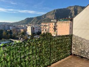 Una valla cubierta de hiedra en un edificio con una ciudad en La casetta di Memy, en Nápoles