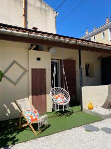 a patio with two chairs and a swing at Le petit soleil, 5 mn de la plage et de l'embarcadère, parking et wifi gratuits in Toulon
