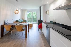 a kitchen and living room with a table and a dining room at Las casitas de mache - LAGOSSA in Cerler