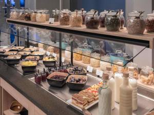 Un buffet con muchos alimentos diferentes en exhibición. en Mercure Hotel München Neuperlach Süd, en Múnich