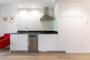 a kitchen with white cabinets and a sink at Las casitas de mache - LAGOSSA in Cerler +7 photos