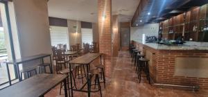 eine Bar in einem Restaurant mit Holztischen und Hockern in der Unterkunft Hotel Rural Atalaya in Guadalupe