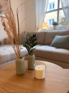 a table with a candle and two vases on it at Fewo Eirich in Günzburg