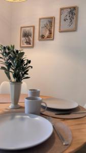 a wooden table with plates and a vase on it at Fewo Eirich in Günzburg