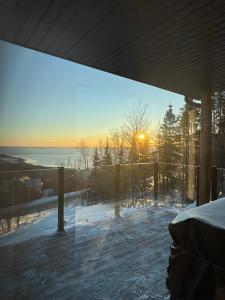 a screened in porch with a view of the ocean at Vertigo - Fleuve & Montagnes in Les Éboulements