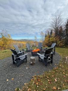 a group of picnic tables and chairs on a gravel area at Vertigo - Fleuve & Montagnes in Les Éboulements +19 photos