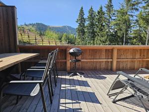a patio with chairs and a grill on a deck at The Lodges am Klippitztörl - Chalet in Klippitztorl