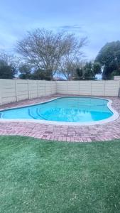 een zwembad in een tuin met een hek bij Croydon Vista Luxe in Kempton Park