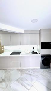 a kitchen with white cabinets and a sink at Las Americas 200A apartment in Costa de Adeje +14 photos