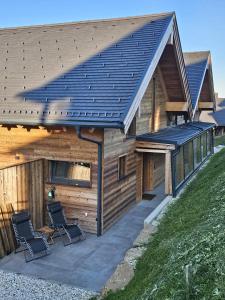 two chairs sitting on a patio in front of a building at The Lodges am Klippitztörl - Chalet in Klippitztorl