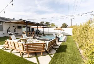 einen Hinterhof mit Pool, Stühlen und Sonnenschirm in der Unterkunft Bonita Oasis in Scottsdale