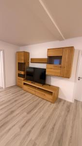 a living room with wooden cabinets and a flat screen tv at Ferienwohnung im Ellertal in Bockelnhagen +8 photos