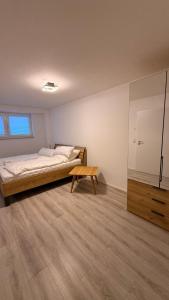 a bedroom with a bed and a wooden table at Ferienwohnung im Ellertal in Bockelnhagen