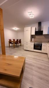 a kitchen with white cabinets and a wooden table at Ferienwohnung im Ellertal in Bockelnhagen