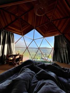 a large bed in a room with a large window at Vila Rosa Lodges - Chalés e Domo in Praia Grande +114 photos