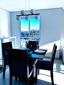 a dining room with a table and chairs and a window at Charmoso Duplex com Jacuzzi in Poços de Caldas