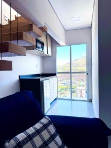 a room with a bed and a staircase with a window at Charmoso Duplex com Jacuzzi in Poços de Caldas