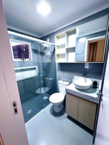 a bathroom with a toilet and a sink and a shower at Charmoso Duplex com Jacuzzi in Poços de Caldas