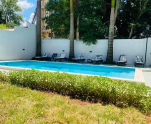 a swimming pool with chairs and a fence at THE HEIRS Departamentos in Posadas
