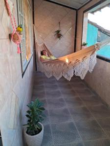 un hombre durmiendo en una hamaca en una habitación en Brachil 2, en Búzios