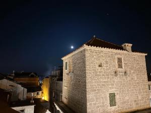 a night view of a building with the moon behind it at Downtown stone house in Vodice