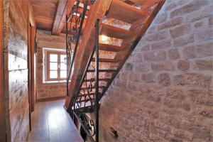 a wooden spiral staircase in a brick wall at Downtown stone house in Vodice
