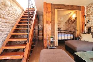 a room with a spiral staircase and a bedroom at Downtown stone house in Vodice