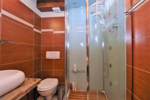 a bathroom with a toilet and a glass shower at Downtown stone house in Vodice +6 photos