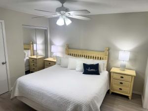 une chambre avec un lit blanc avec un ventilateur de plafond dans l'établissement Island Sands 103 Gulf front condo, à Fort Walton Beach