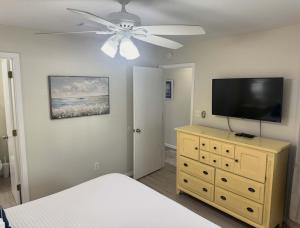 une chambre avec un ventilateur de plafond et une télévision sur une commode dans l'établissement Island Sands 103 Gulf front condo, à Fort Walton Beach