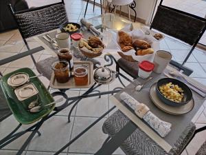een tafel met borden eten bovenop bij Maison d'hôtes Beauregard in Donneville