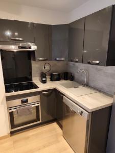Charmant 3 pieces 2 chambres et parking في بونتولت-كومْبو: مطبخ مع حوض وموقد