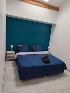 Charmant 3 pieces 2 chambres et parking في بونتولت-كومْبو: غرفة نوم بها سرير وجدار أزرق