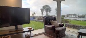 Ferry Lodge Cottage في غابات كيلرَش: غرفة معيشة مع تلفزيون بشاشة مسطحة وكرسي