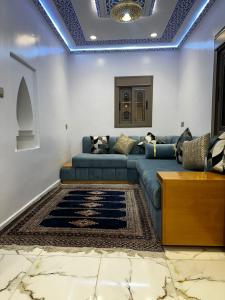 a living room with a blue couch and a rug at Dar Ouadie the pearl stay in Chefchaouen +18 photos