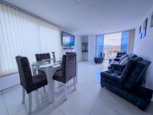 a dining room with a table and chairs and a television at Amplio Y Lujoso Apartasuite En El Centro in Cartago